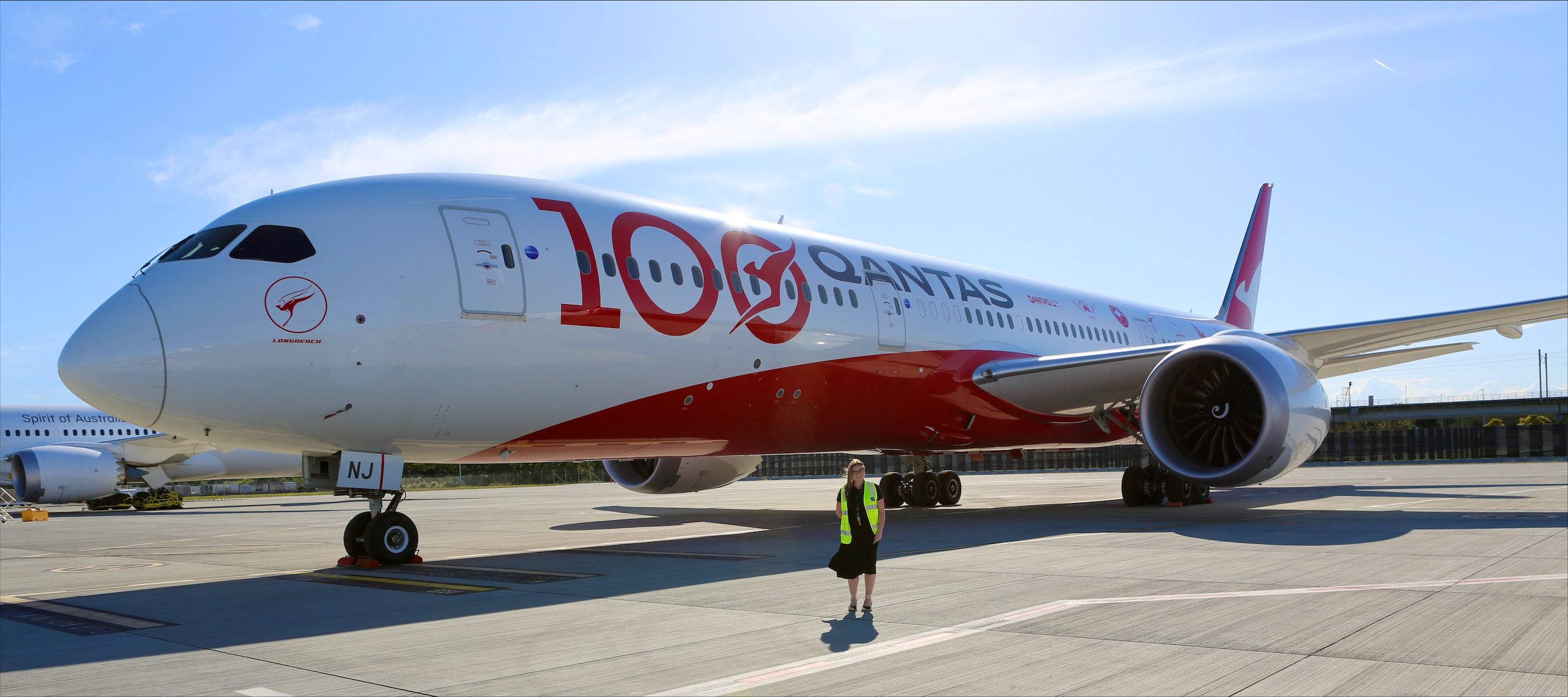 Maddy standing in front of a Qantas plane